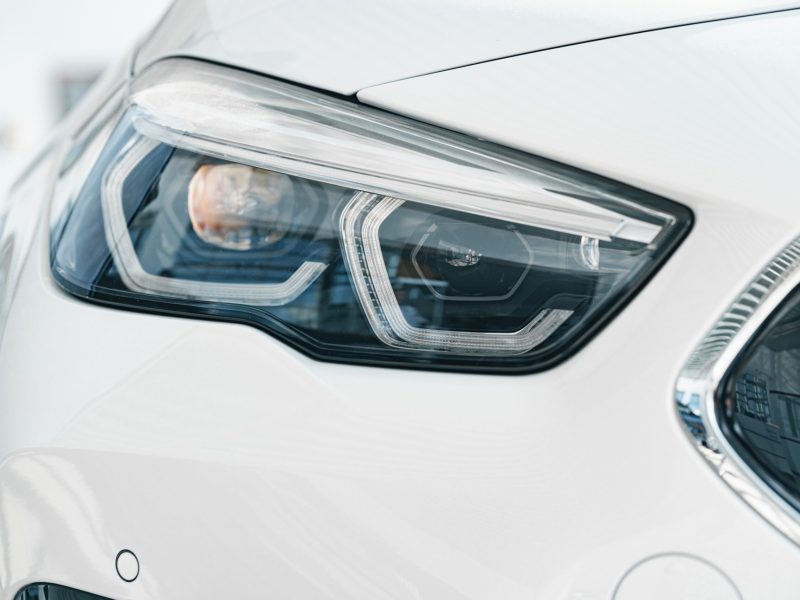 Headlights of a new white luxury car close up
